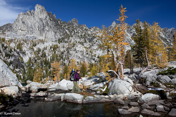 Hiker Crossing the Lake Outlet